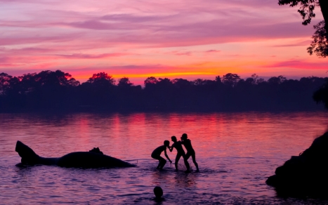 Kids in river at sunset