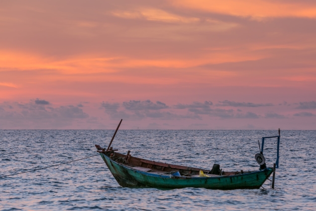 Fishing boat on water at sunset